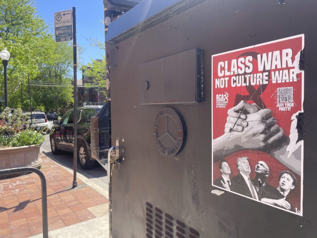 a flyer for the Revolutionary Communists of America Party on a black electrical box reading CLASS WAR NOT CULTURE WAR with pictures of Elon, Trump, Bezos, and Zuckerberg.
