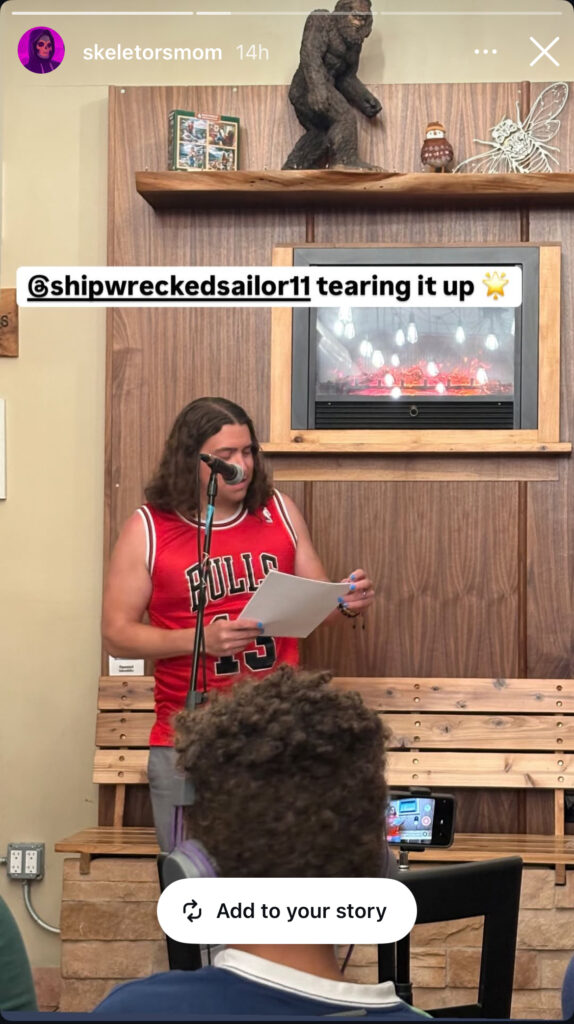 a mean in a Joakin Noah Bulls jersey reads poems while a child looks on.