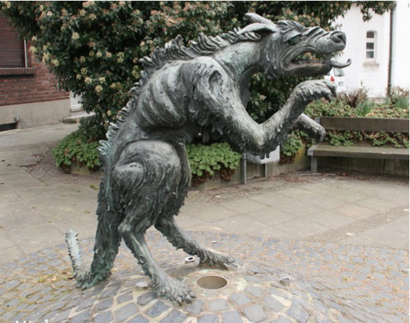 a public art statue of a Platschonnk, a part-dragon, mostly-werewolf, tongue-out creature that loks a touch wrinkly and mangy, like he needs some hot soup. 