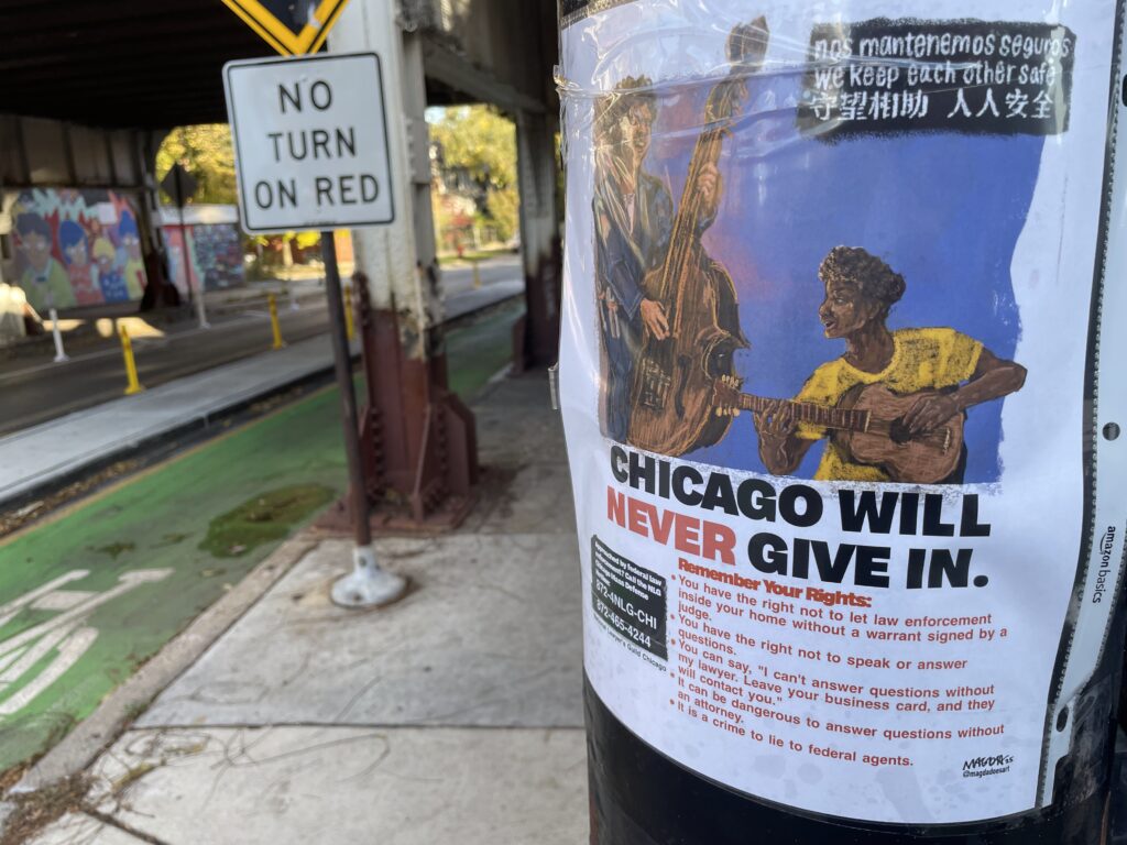 flyer on a telephone pole with two Black musicians playing upright bass and guitar and reading CHICAGO WILL NEVER GIVE IN with Remember Your Rights language