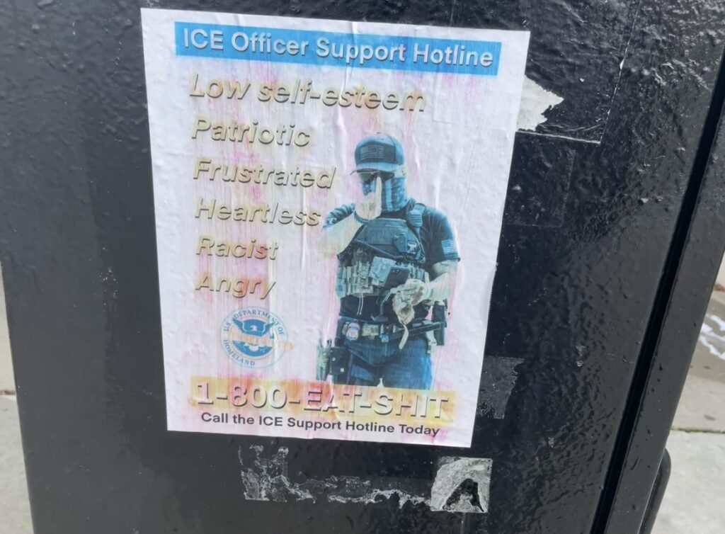 a flyer on a black electrical box reading ICE Officer Support Hotline Low self-esteem Patriotic Frustrated Heartless Racist Angry 1-800-EAT-SHIT Call the ICE Support Hotline Today