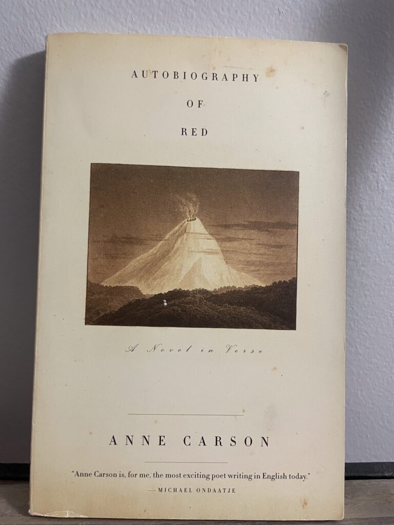 a book, Autobiography of Red by Anne Carson, on a shelf