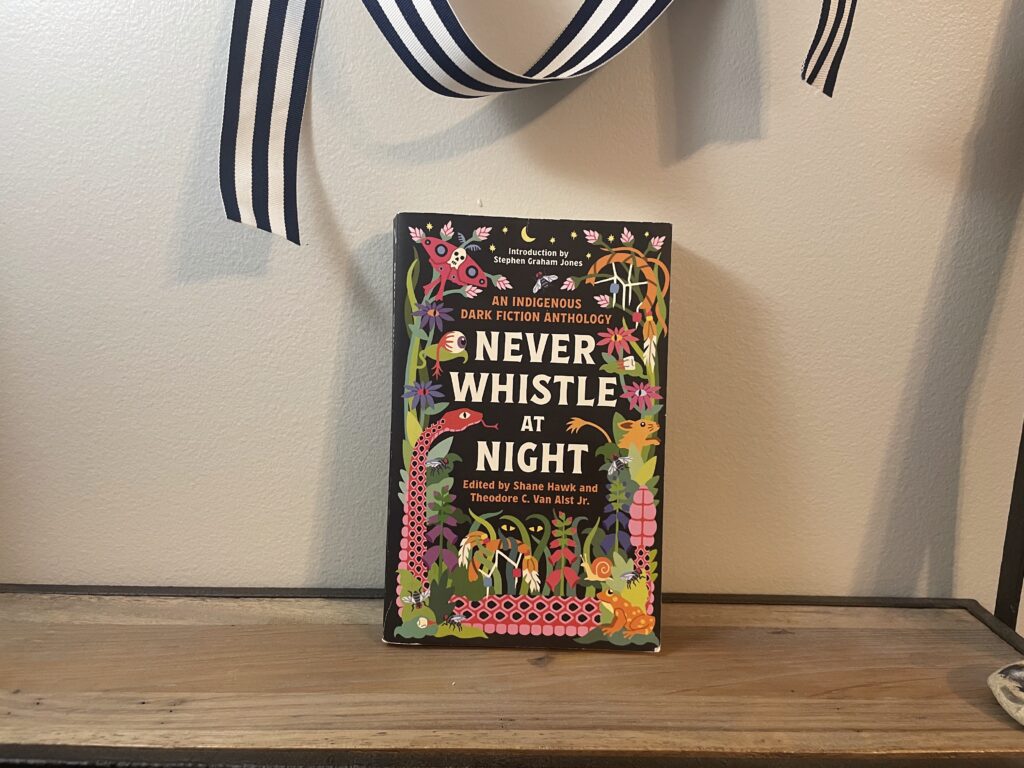 a book, Never Whistle At Night, on a shelf
