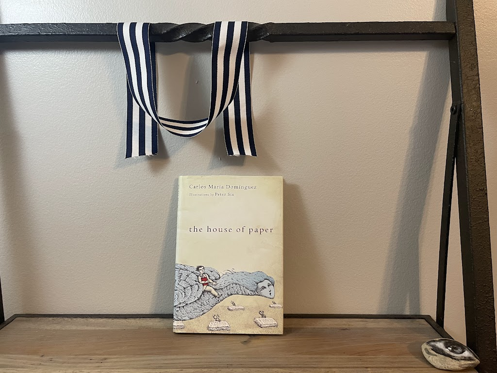 a book, THE HOUSE OF PAPER by Carlos María Domínguez, on a shelf